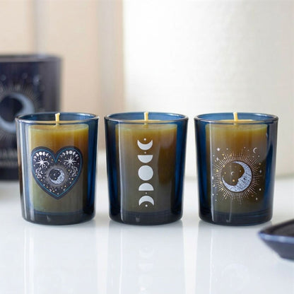 Witchy decor gift set featuring three deep blue glass moon phase candle holders containing pure, unlit beeswax candles.