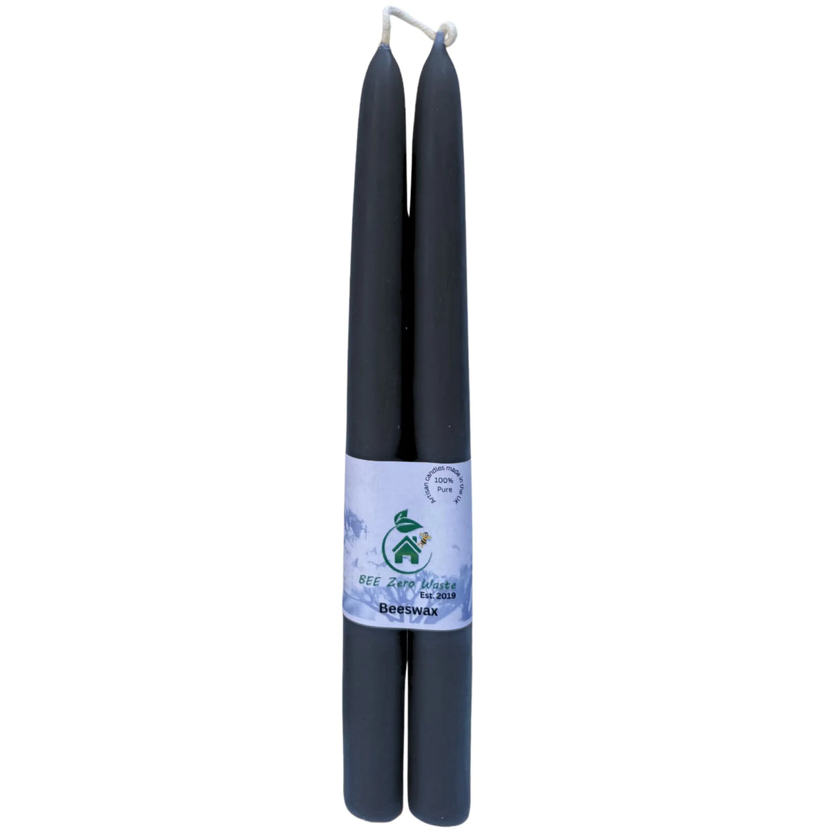Two black beeswax taper candles wrapped together with a white paper band featuring a green logo and text, set against a plain white background.