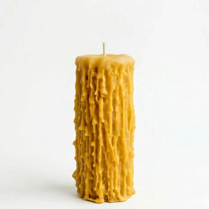 A flat-lay inspired scene featuring a set of dripped beeswax candles paired with vintage matches and dried botanical stems, illustrating their use as a sustainable, eco-friendly gift or wedding centerpiece.