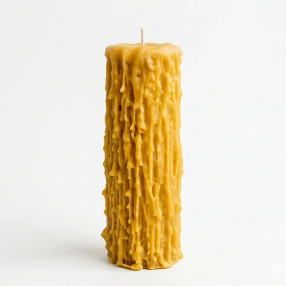 An overhead perspective of a handmade beeswax candle showing the natural cotton wick and the thick, organic pooling of wax at the top, emphasizing its non-toxic and paraffin-free composition.