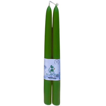 Two green pure beeswax  tapers candles wrapped together with a white paper band label, shown against a plain white background.