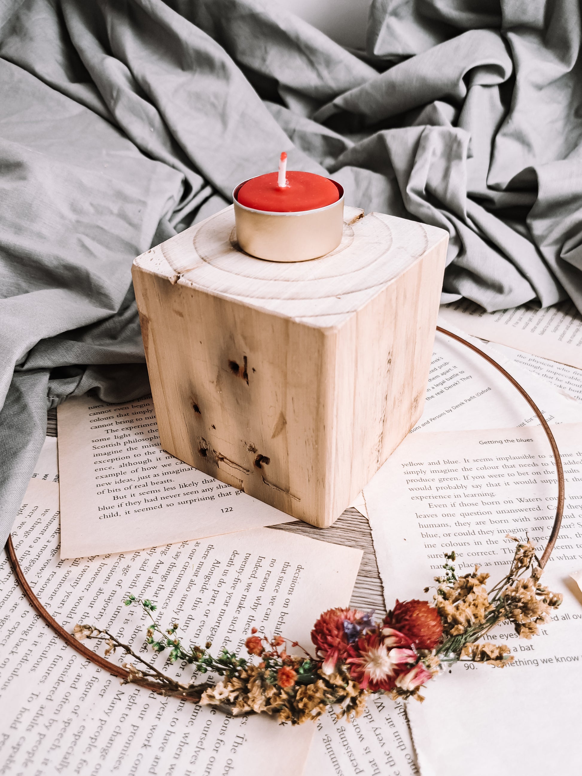 Hand-poured red beeswax tealights displayed on a wooden table